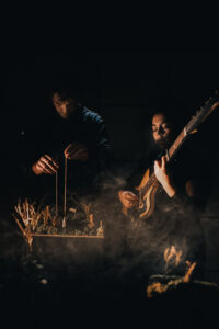 Musikerin und Figurenspieler in schummrigem Licht