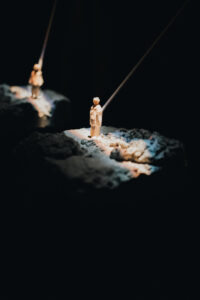 Zwei Holzfiguren zwischen Licht und Schatten